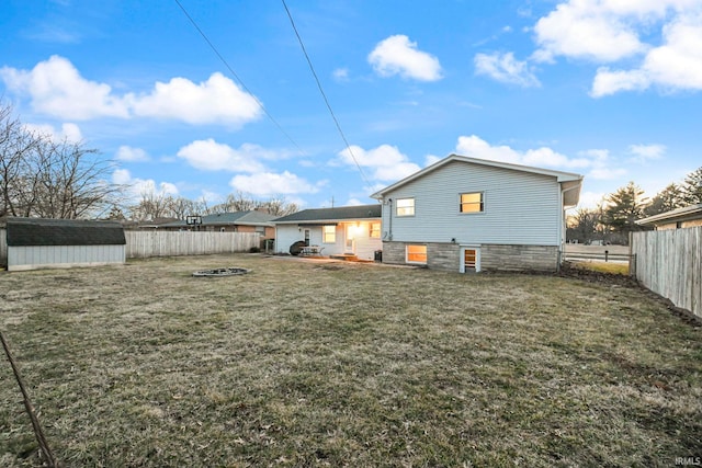 back of property with an outdoor fire pit, a lawn, and fence