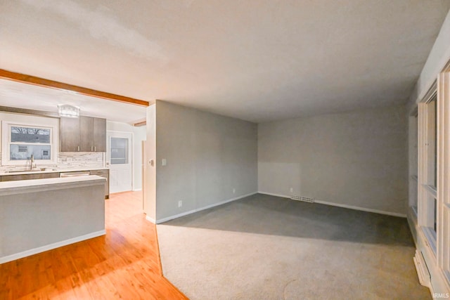 interior space featuring light wood-type flooring, a sink, and baseboards