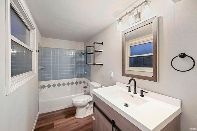 full bath featuring washtub / shower combination, vanity, wood finished floors, and toilet