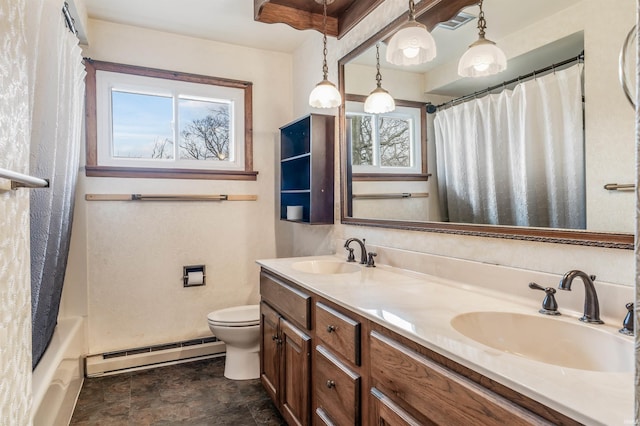 bathroom with a baseboard heating unit, double vanity, a sink, and toilet