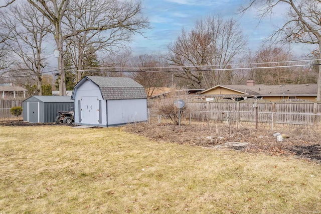 view of yard featuring a storage shed, an outbuilding, and a fenced backyard