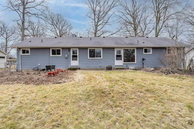 back of property featuring entry steps and a yard