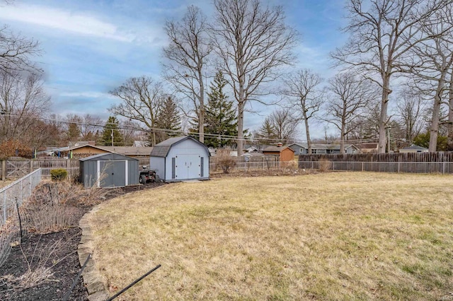 view of yard featuring a shed, a fenced backyard, and an outdoor structure