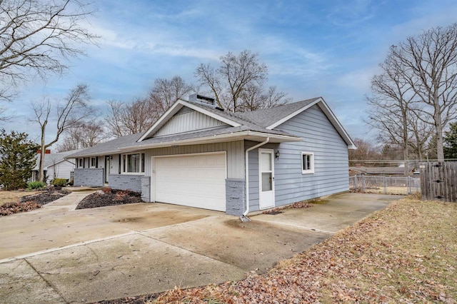 view of home's exterior with a garage, driveway, roof with shingles, fence, and board and batten siding