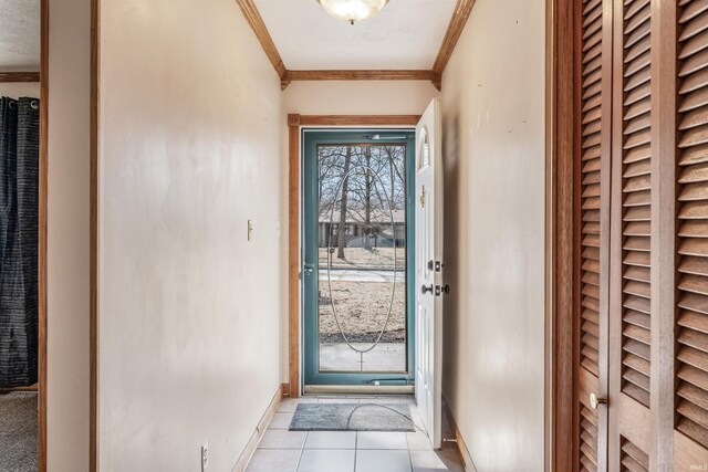 doorway to outside with baseboards, light tile patterned flooring, and crown molding