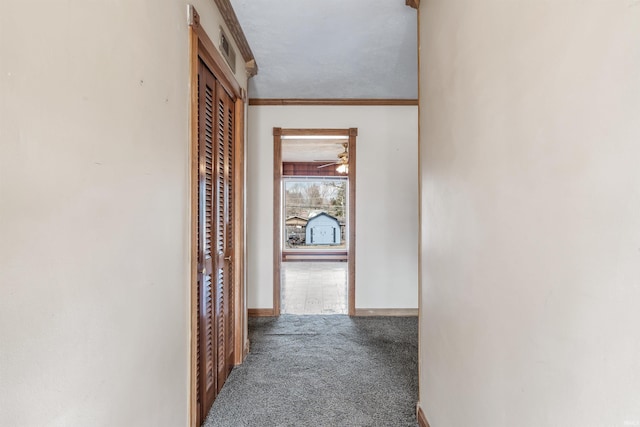 hallway featuring baseboards, carpet flooring, and ornamental molding