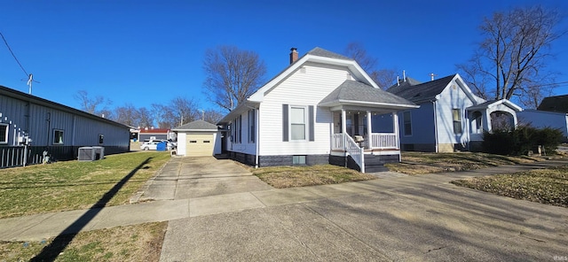 bungalow-style house featuring a shingled roof, concrete driveway, covered porch, an outdoor structure, and a front yard