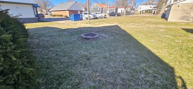 view of yard with a fire pit and a residential view