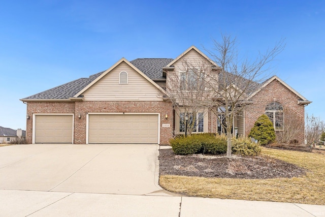 traditional home with a garage, concrete driveway, brick siding, and a shingled roof