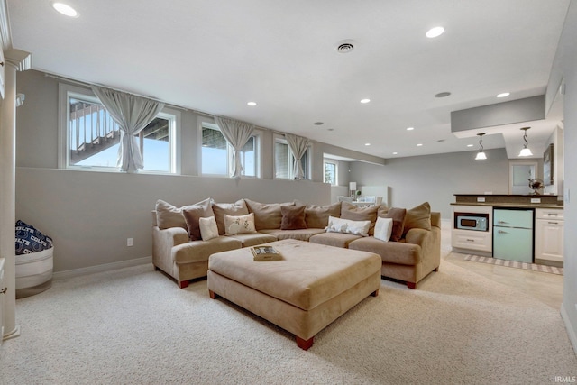 living area with baseboards, visible vents, and recessed lighting