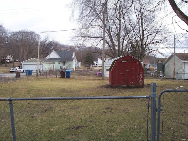 view of yard with a residential view, a gate, a shed, fence private yard, and an outdoor structure