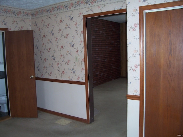 unfurnished room with wallpapered walls, baseboards, and wainscoting