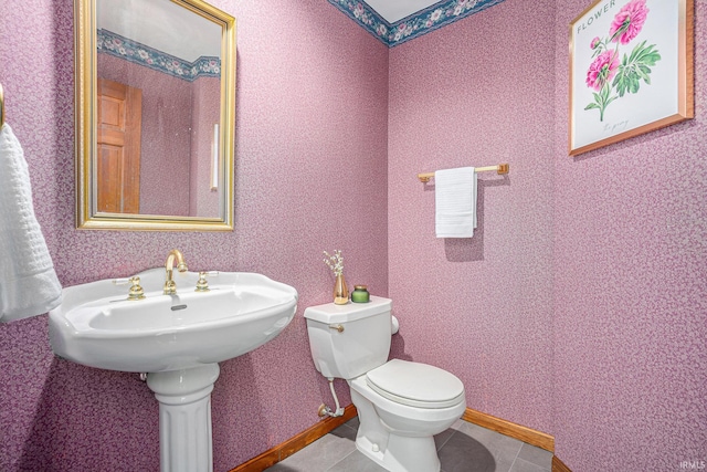 bathroom with tile patterned floors, baseboards, toilet, and wallpapered walls