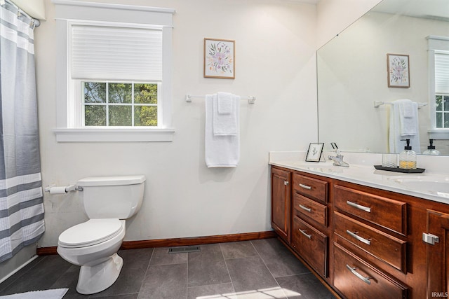 bathroom featuring double vanity, baseboards, visible vents, toilet, and a sink