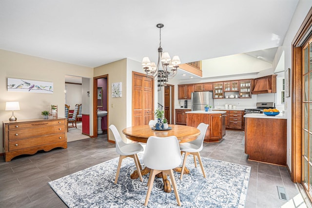 dining space with a chandelier, vaulted ceiling, and baseboards