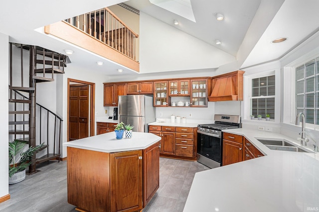 kitchen with a sink, light countertops, appliances with stainless steel finishes, custom exhaust hood, and brown cabinets