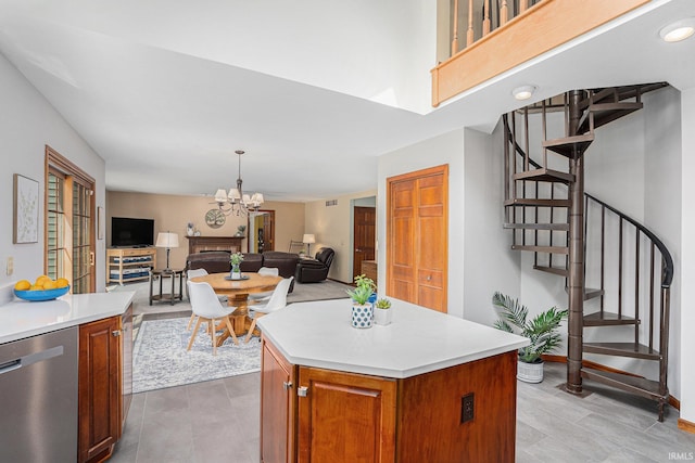 kitchen with a kitchen island, open floor plan, stainless steel dishwasher, and light countertops