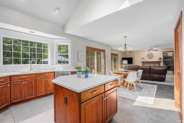 kitchen featuring lofted ceiling, a sink, open floor plan, light countertops, and a center island