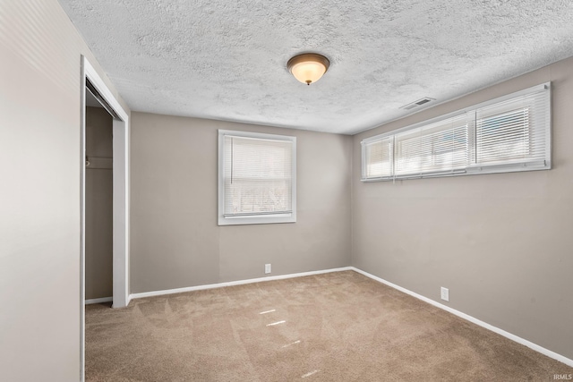 unfurnished bedroom featuring baseboards, a closet, visible vents, and carpet flooring