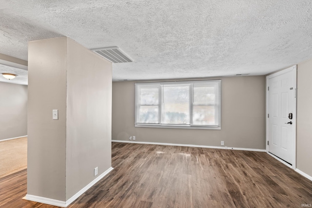 interior space with wood finished floors, visible vents, and baseboards