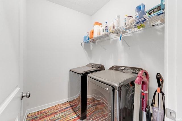 laundry room with laundry area, washer and clothes dryer, and baseboards