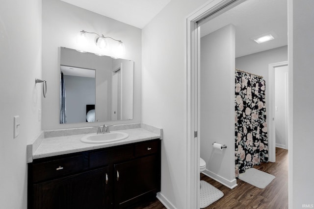 full bath featuring baseboards, toilet, wood finished floors, curtained shower, and vanity