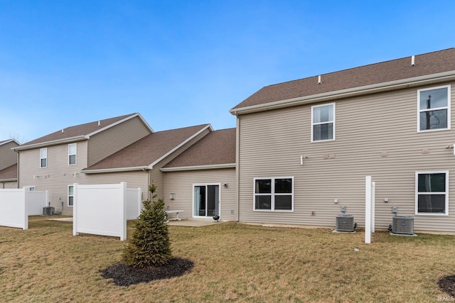 back of house featuring a lawn, fence, and central air condition unit