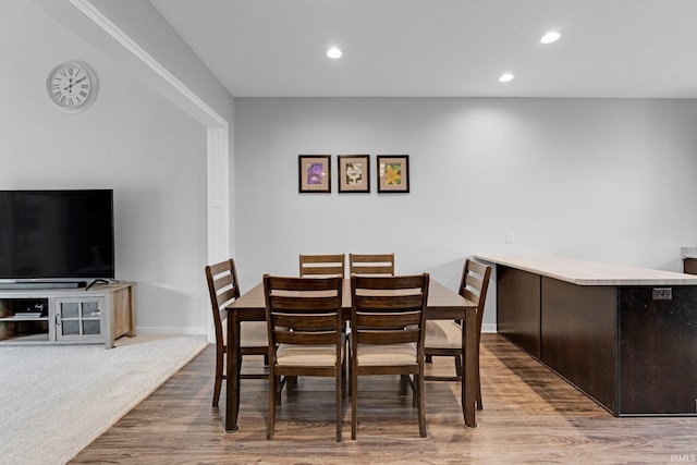 dining space featuring baseboards, wood finished floors, and recessed lighting