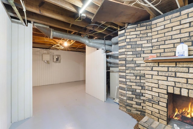 unfinished below grade area with a brick fireplace and electric panel