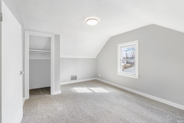 additional living space featuring lofted ceiling, carpet, visible vents, and baseboards