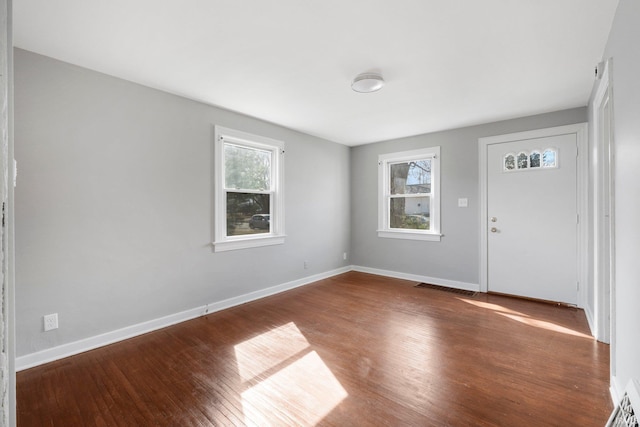 interior space featuring plenty of natural light, wood finished floors, visible vents, and baseboards