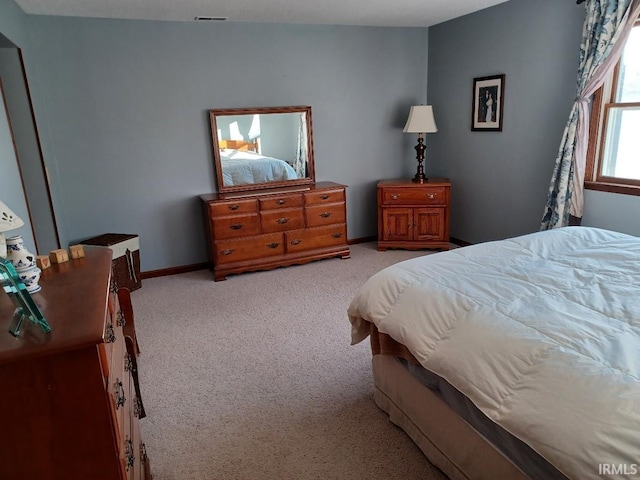 bedroom featuring light colored carpet, visible vents, and baseboards