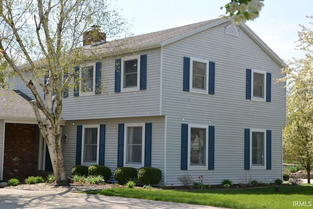 exterior space with a chimney and a front yard