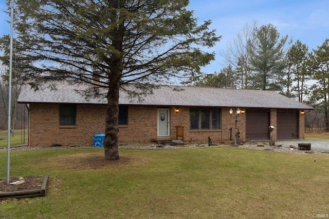 single story home featuring a garage, driveway, a front lawn, and brick siding