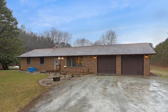 single story home with dirt driveway, a chimney, an attached garage, a front lawn, and brick siding