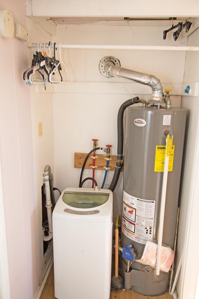 utility room with gas water heater and washer / dryer