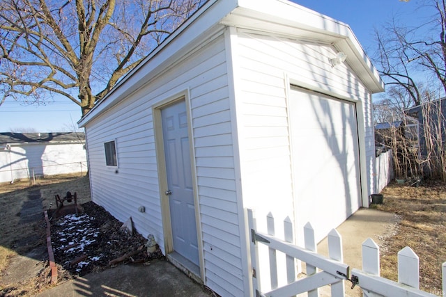 view of outbuilding featuring fence and an outdoor structure