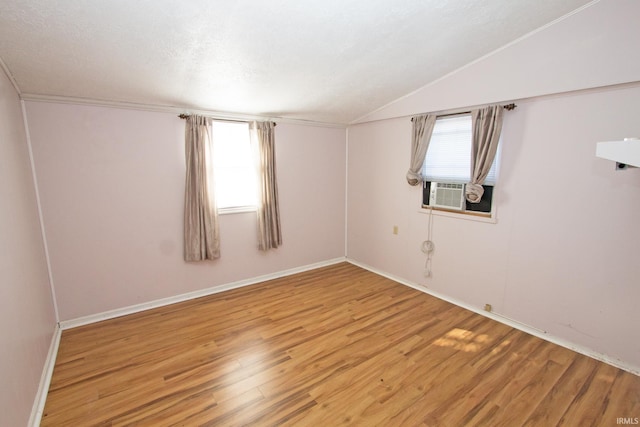 spare room with lofted ceiling, light wood-style floors, and plenty of natural light