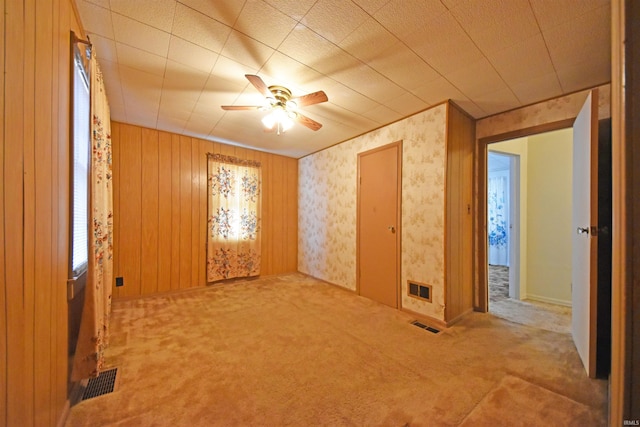 unfurnished room featuring visible vents, ceiling fan, and carpet flooring