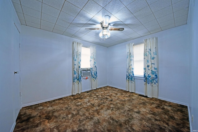 carpeted spare room with a ceiling fan, cooling unit, and baseboards