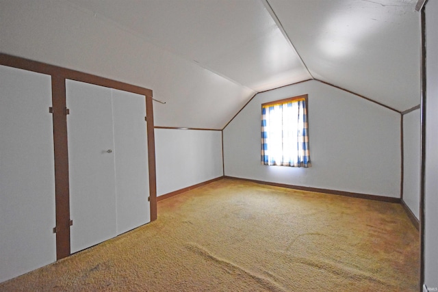 additional living space with carpet floors, vaulted ceiling, and baseboards