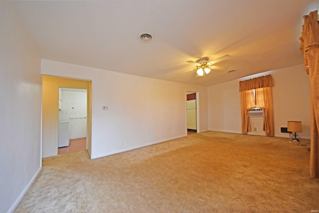 spare room with light carpet, baseboards, visible vents, and a ceiling fan