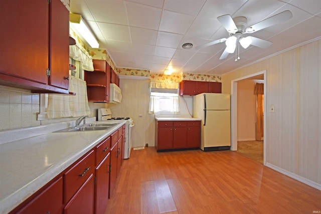 kitchen with white appliances, red cabinetry, light countertops, light wood-style floors, and open shelves