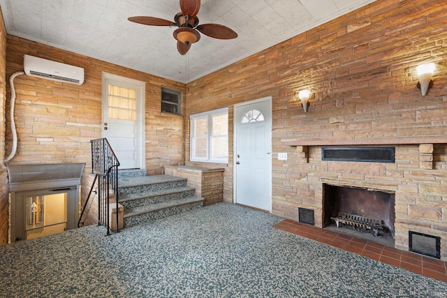 living area with a stone fireplace, carpet floors, a ceiling fan, stairs, and a wall mounted air conditioner