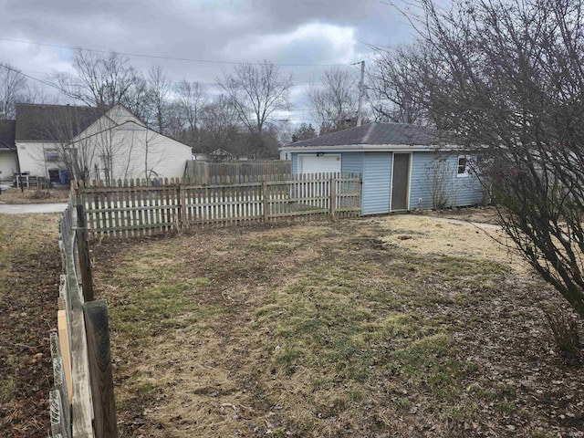 view of yard featuring fence and an outbuilding