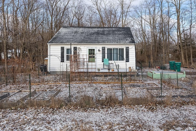 view of front of house featuring a garden and a shingled roof