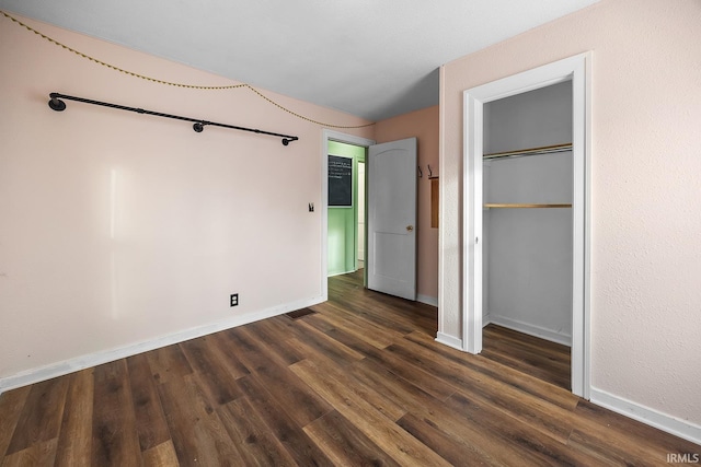 unfurnished bedroom with baseboards, dark wood finished floors, and a closet