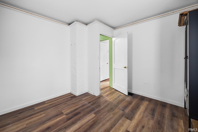 unfurnished room with baseboards and wood finished floors