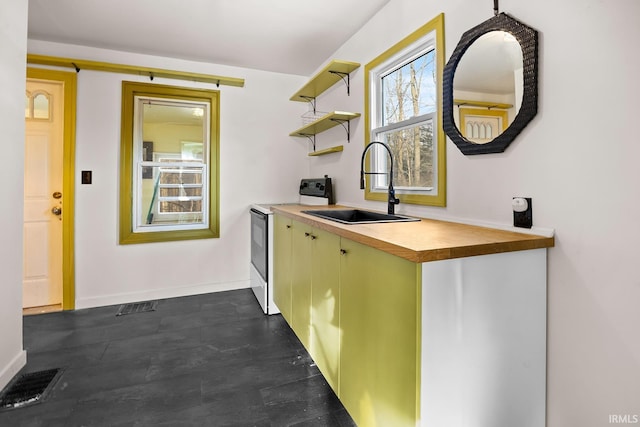 kitchen featuring white range with electric stovetop, open shelves, visible vents, a sink, and baseboards