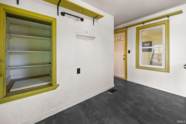 interior space featuring dark wood-type flooring, visible vents, and baseboards